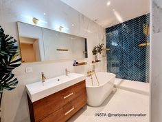 a bathroom with a tub, sink and large mirror in the corner next to it