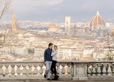 a man and woman standing next to each other in front of a cityscape