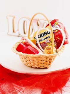 a basket filled with various items sitting on top of a white tablecloth next to the word love