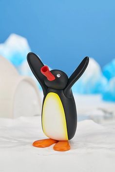 a small toy penguin is standing on its hind legs