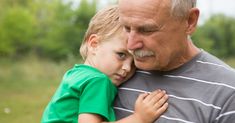 an older man holding a young boy in his arms