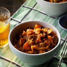 a bowl filled with food next to a glass of beer