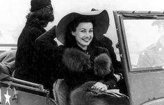 a woman sitting in the back of an old car