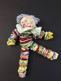 a small doll made out of fabric on a black surface