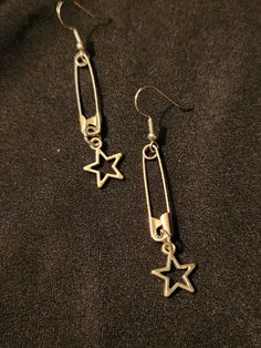 Safety pins on earring hooks, accented with open (hollow) star charms, set of 2 earrings, each measures about 2.5 inches.  Silver tone.  Handmade, unisex jewelry.  Ready to ship. To continue shopping: http://www.rrrobinnn.etsy.com Early 2000 Jewelry, Home Made Earing, Tom Boy Jewelry, Cool Earings Ideas, Bottle Tab Earrings, Safety Pin Chain, Tomboy Jewelry Accessories, Grunge Jewelry Diy, Masc Accessories