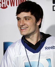 a young man wearing a jersey and beaded necklace