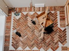 an overhead view of a brick wall with tools on the floor and construction materials around it