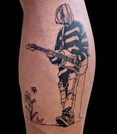 a man with a guitar tattoo on his leg