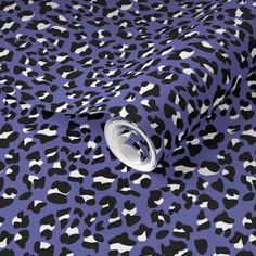 an animal print fabric with black and white spots on purple background, suitable for wallpaper