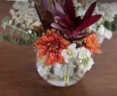 a vase filled with flowers on top of a wooden table