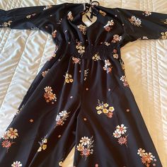 Brand New Jumpsuit Never Got To Wear. Size Large Casual Black Floral Jumpsuits And Rompers, Black Jumpsuits And Rompers For Spring Day Out, Black Jumpsuits And Rompers For Day Out In Spring, Black Floral Print Jumpsuits And Rompers For Workwear, Black Long Sleeve Jumpsuits And Rompers For Spring, Casual Floral Print Jumpsuits For Work, Black Floral Jumpsuit, Boutique Pants, Floral Jumpsuit