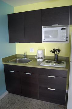 a kitchen with a microwave, sink and refrigerator freezer combination in the wall next to each other