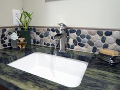 a white sink sitting under a faucet next to a bathroom mirror and counter top