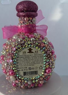 a bottle that has some kind of decoration on it's top and is decorated with beads