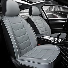 the interior of a car with black and white leather seats, steering wheel cover and center console