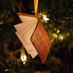 an ornament hanging from a christmas tree decorated with red and white paper squares