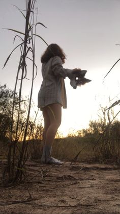 a woman standing in the middle of a field