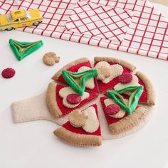 there is a felt pizza with toppings on the table next to other toys and decorations