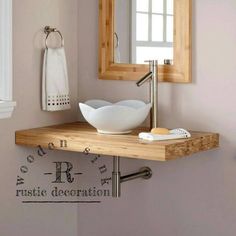 a bathroom sink sitting under a mirror on top of a wooden counter next to a towel rack