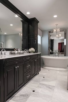 a large bathroom with marble floors and black cabinets