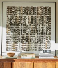 a wooden dresser topped with books next to a wall mounted art piece on top of it