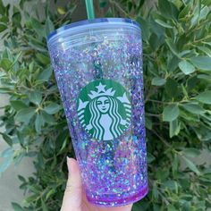 someone holding up a starbucks cup with purple and blue sprinkles