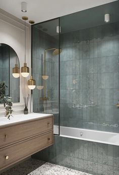 a bathroom with green tile and gold fixtures