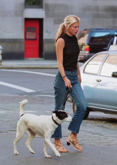 a woman walking her dog down the street