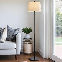 a living room with a white couch and floor lamp