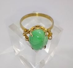 Elaborate vintage 14ct gold and carved green jade ring Perfect condition  Marked 585 for 14ct gold The front of the ring measures 1.4cm at the widest point and sits at 0.8cm off the finger  UK ring size T, US size 9 1/2 Vintage Jade Ring, Green Carved Rings For Formal Occasions, Formal Carved Green Ring, Formal Green Carved Ring, Green Carved Jade Rings, Carved Green Jade Rings, Antique Green Emerald Ring Stamped 14k, Vintage Carved Green Ring, Vintage Green Carved Ring