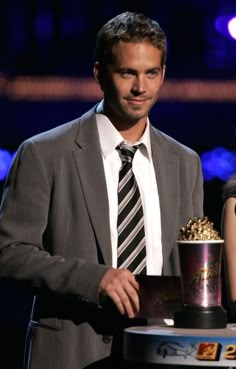 a man and woman standing next to each other with a trophy in front of them