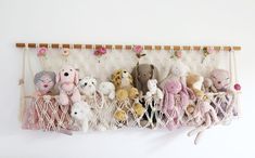 several stuffed animals are hanging in a hammock with flowers on the wall behind them