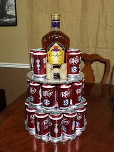 a stack of beer cans sitting on top of a wooden table