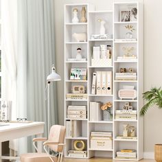 a white bookcase filled with lots of books next to a desk and chair in front of a window