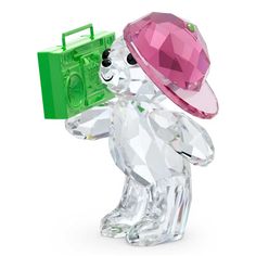 a crystal bear with a pink hat and green box on its head, holding a camera