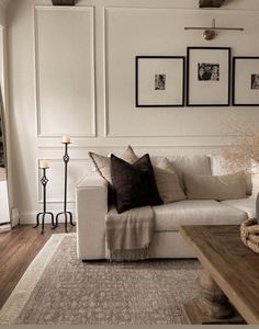 a living room filled with furniture and pictures on the wall