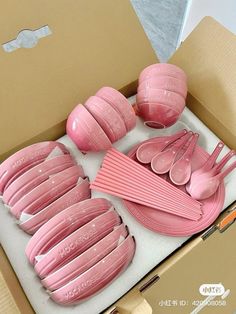 a box filled with pink plastic cups and spoons next to an open cardboard box