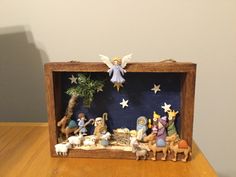 a nativity scene in a wooden frame on a table