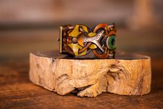 Embrace the fusion of craftsmanship and mystical allure with our Handmade Steampunk Bohemian Leather Cuff Bracelet. This unisex piece is a symphony of details, featuring an intricately carved and painted eyeball and mushrooms, surrounded by geometric patterns inspired by sacred geometry. The design is a bold testament to both artistic vision and spiritual symbolism. Rendered in rich, earthy tones of brown, green, and black, this bracelet interweaves multiple leather strips, creating a complex and textured aesthetic. The antique brass buckle closure adds a vintage touch while ensuring a comfortable fit for wrist sizes ranging from 7 to 9.25 inches. Perfect for festivals like Burning Man, spiritual gatherings, or everyday wear, this leather cuff serves as more than just an accessory—it's a p Vintage Hand Tooled Bracelets For Festivals, Handmade Leather Cuff Bracelet For Festival, Adjustable Multicolor Patina Jewelry, Unique Leather Cuff Bracelet For Festival, Adjustable Unique Leather Bracelet For Festivals, Unique Festival Cuff Bracelet, Unique Cuff Bracelet For Festival, Brown Cuff Jewelry For Festivals, Brown Cuff Jewelry For Festival