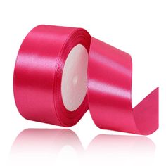 a roll of pink satin ribbon on a white background