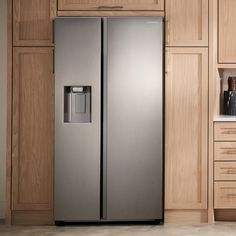 a stainless steel refrigerator in a kitchen with wooden cabinets