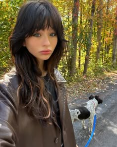 a woman is holding her dog on a leash