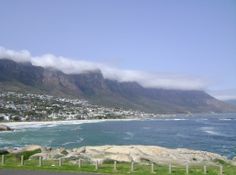 the ocean and mountains are covered with clouds in cape town, south africa on a sunny day