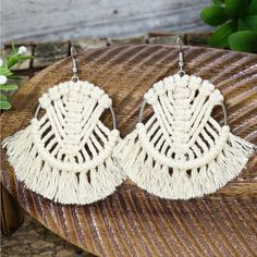 two pairs of white earrings on top of a wooden table