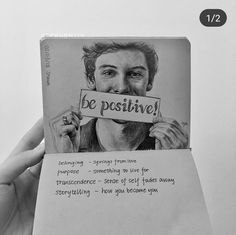 a person holding up a piece of paper with the words be positive written on it