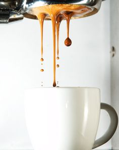 coffee being poured into a white cup