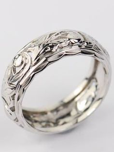 the wedding ring is made from silver and has an intricate floral design on the side