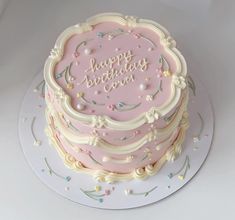 a pink birthday cake sitting on top of a white plate