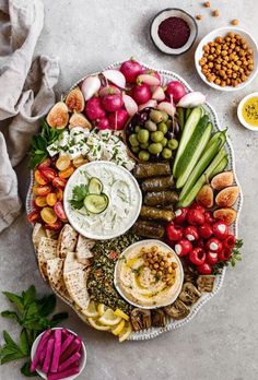 a platter filled with different types of food and dips on top of it