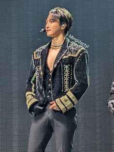 the man is wearing a black jacket and pants with gold trimmings on it